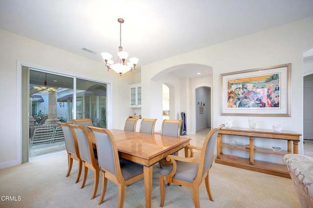 carpeted dining room with a notable chandelier