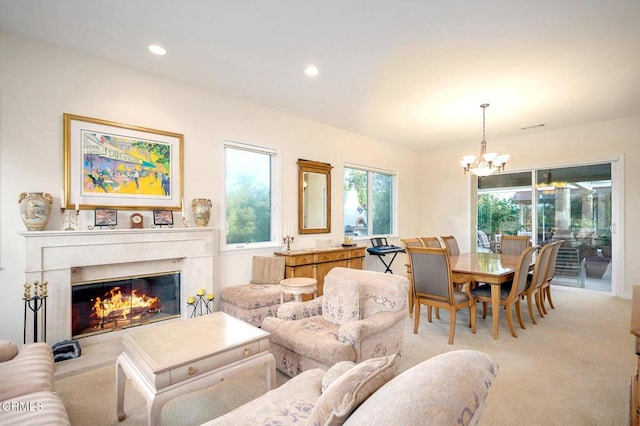 living room featuring light colored carpet, a notable chandelier, and a premium fireplace