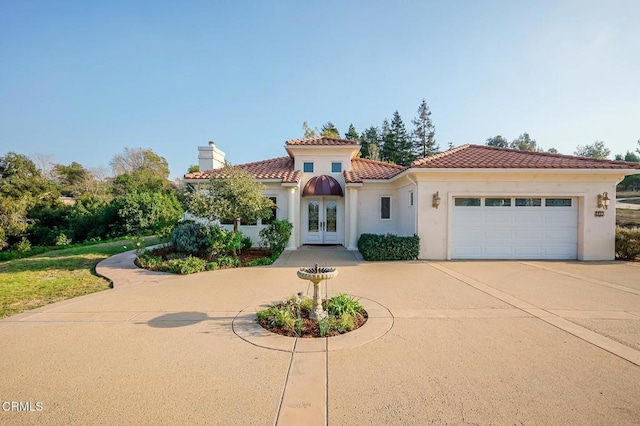 mediterranean / spanish home with french doors and a garage