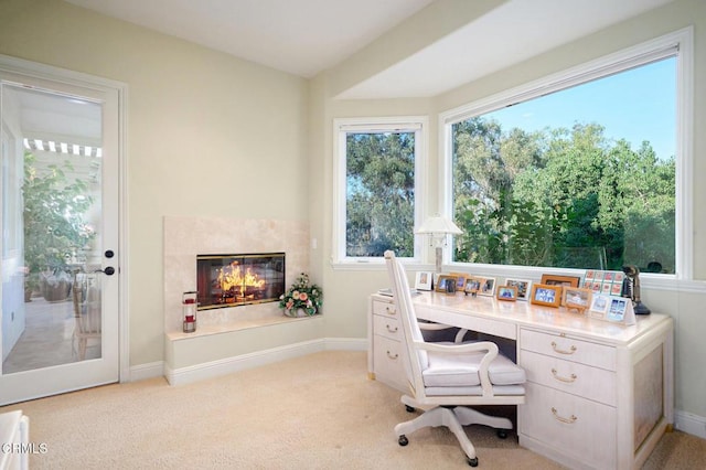 office space with a premium fireplace and light carpet