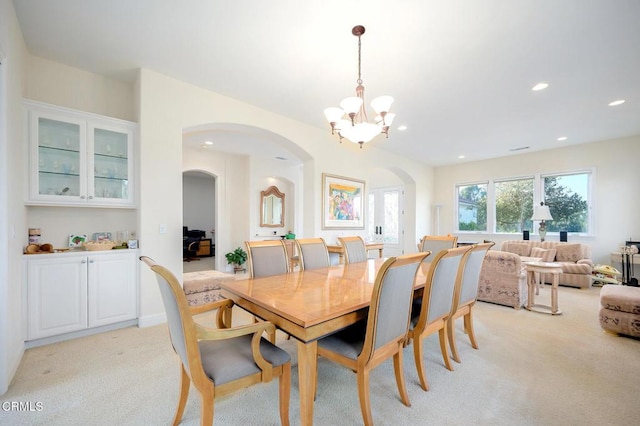 carpeted dining room with a notable chandelier