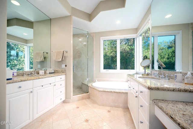 bathroom featuring separate shower and tub, vanity, and a healthy amount of sunlight