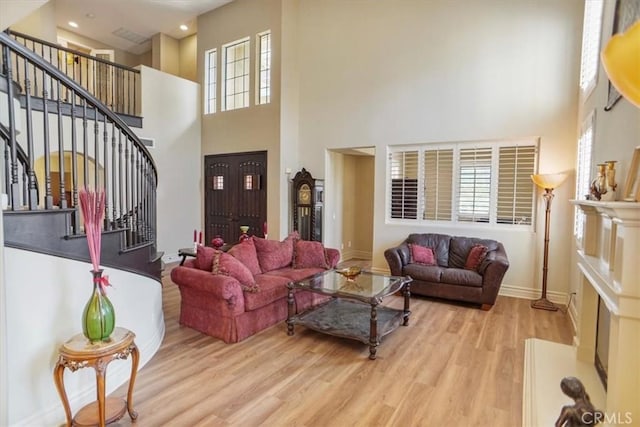 living room featuring a high ceiling and light hardwood / wood-style floors