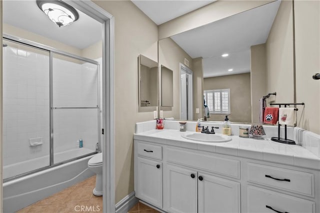 full bathroom featuring toilet, tile patterned flooring, vanity, and combined bath / shower with glass door