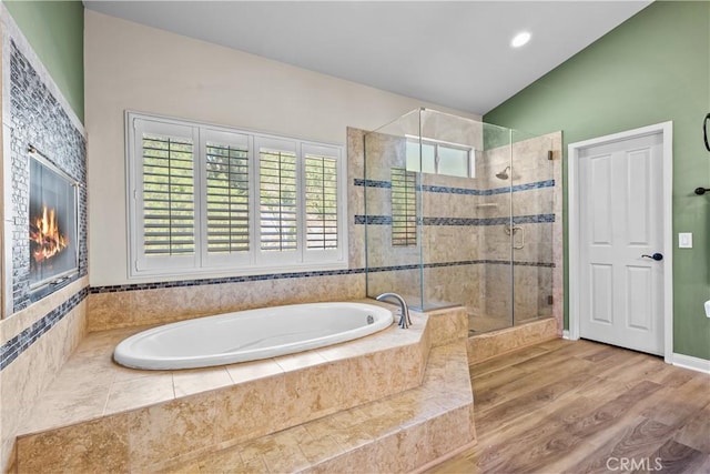 bathroom featuring plus walk in shower, hardwood / wood-style floors, and vaulted ceiling