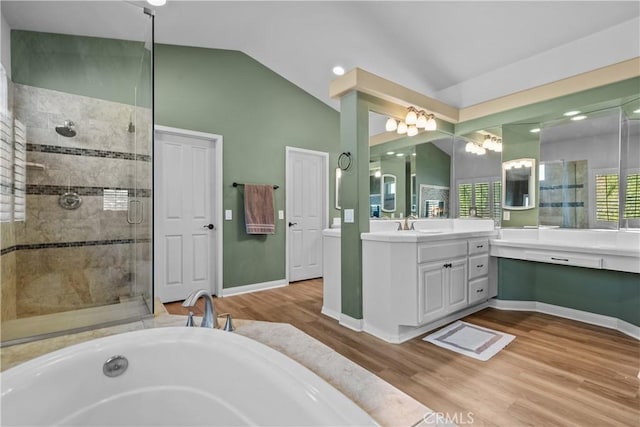 bathroom with hardwood / wood-style floors, vanity, plus walk in shower, and vaulted ceiling