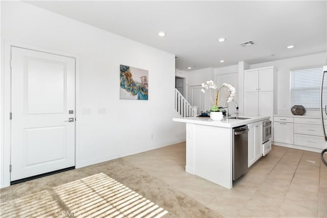 kitchen featuring sink, white cabinetry, appliances with stainless steel finishes, and a kitchen island with sink