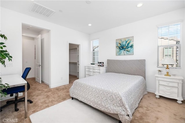 carpeted bedroom featuring a closet and a walk in closet