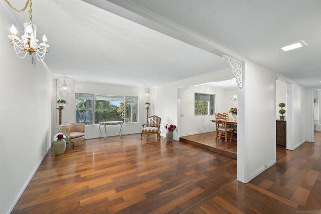 living area with dark hardwood / wood-style flooring and an inviting chandelier