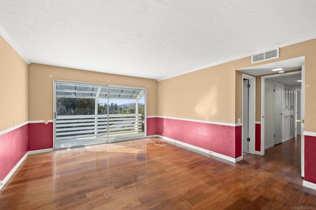 spare room with dark hardwood / wood-style flooring and crown molding