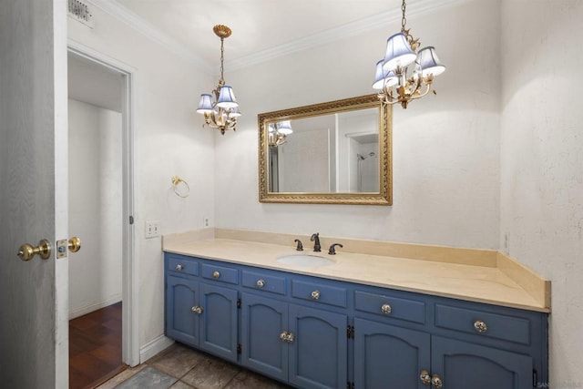 bathroom featuring crown molding, vanity, and a notable chandelier