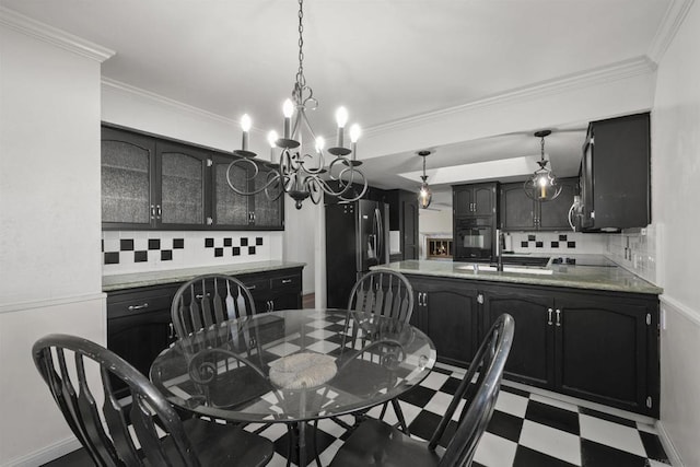 dining space with an inviting chandelier, crown molding, and sink