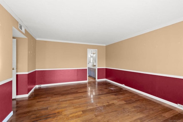 empty room with dark hardwood / wood-style flooring and crown molding