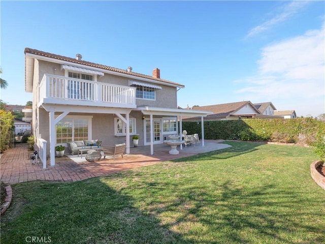 rear view of property with a patio, a yard, stucco siding, a chimney, and outdoor lounge area