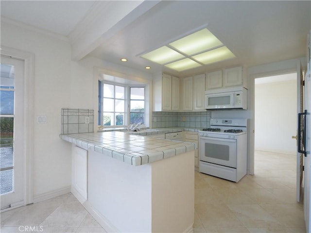 kitchen with tile countertops, beam ceiling, kitchen peninsula, decorative backsplash, and white appliances