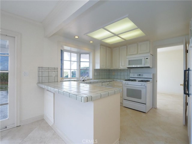 kitchen featuring white appliances, tile countertops, light tile patterned floors, a peninsula, and backsplash