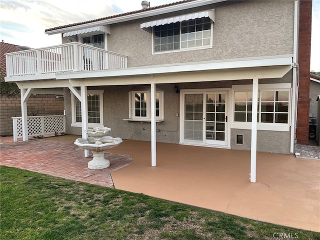 rear view of house featuring a patio and stucco siding