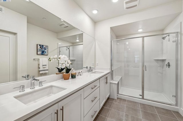 bathroom featuring tile patterned flooring, a shower with door, and vanity