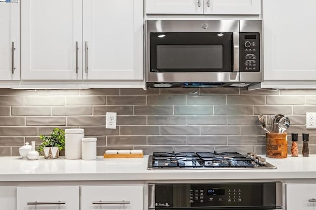 kitchen featuring white cabinets, appliances with stainless steel finishes, and tasteful backsplash