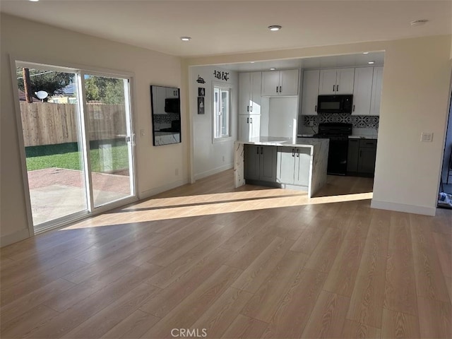 kitchen featuring tasteful backsplash, black appliances, and light hardwood / wood-style floors