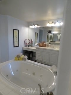 bathroom with tiled tub and vanity