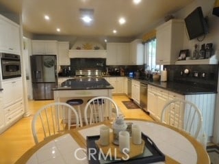 kitchen featuring backsplash, white cabinetry, stainless steel appliances, and a kitchen island