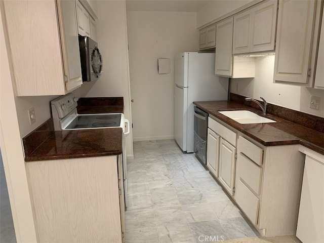 kitchen with cream cabinetry, sink, and stainless steel appliances