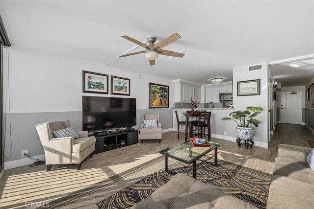 living room featuring dark hardwood / wood-style flooring and ceiling fan