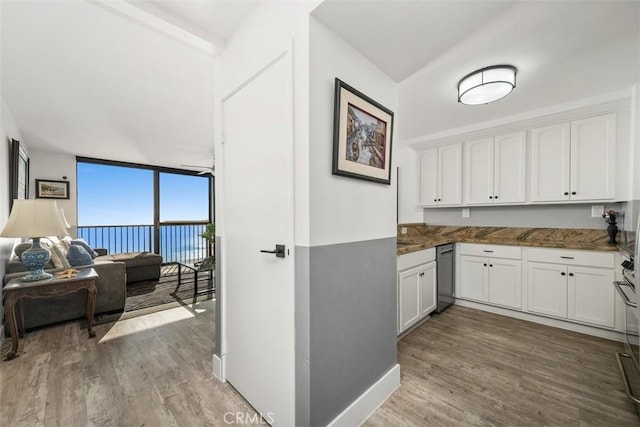 kitchen featuring floor to ceiling windows, dishwasher, light hardwood / wood-style flooring, and white cabinets