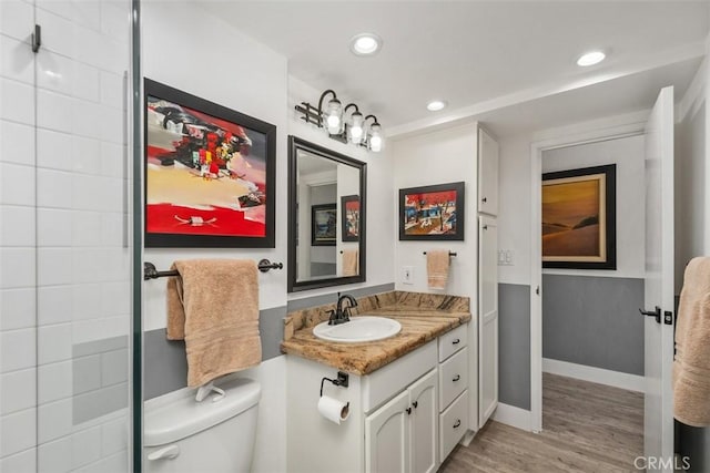 bathroom with vanity, wood-type flooring, and toilet