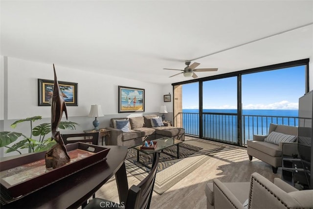 living room featuring expansive windows, ceiling fan, and light hardwood / wood-style floors