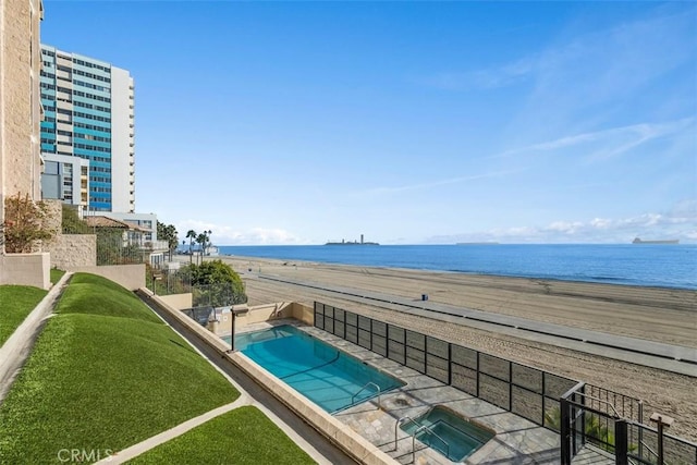 view of pool featuring a view of the beach, a water view, a patio area, and a community hot tub