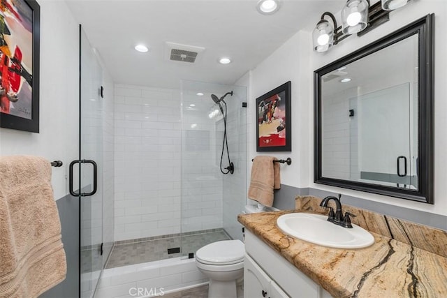 bathroom with vanity, toilet, and an enclosed shower