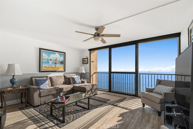 living room featuring light hardwood / wood-style flooring, expansive windows, and ceiling fan