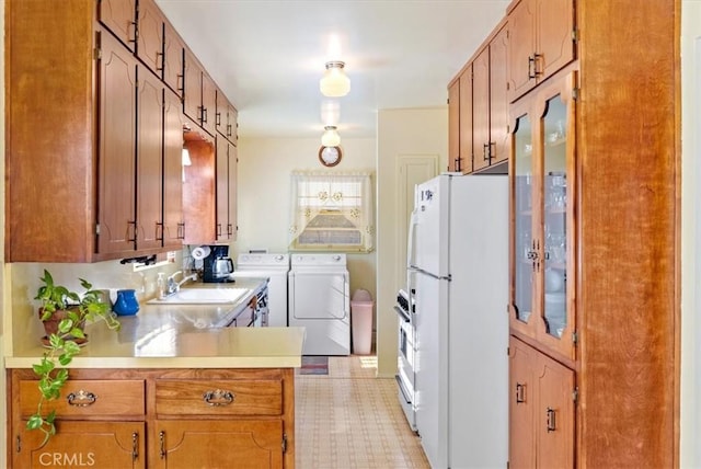 kitchen featuring white refrigerator, washer and clothes dryer, and sink