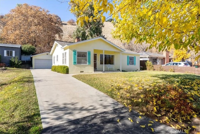 ranch-style home with a garage, an outbuilding, and a front lawn