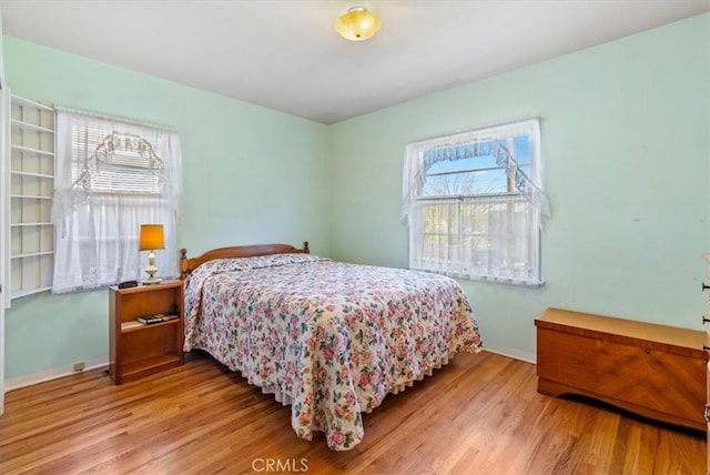 bedroom featuring multiple windows and light wood-type flooring