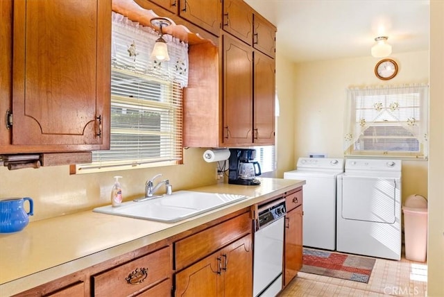 kitchen with dishwasher, sink, pendant lighting, and washing machine and clothes dryer