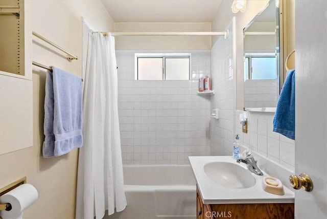 bathroom with vanity, a healthy amount of sunlight, and shower / tub combo with curtain