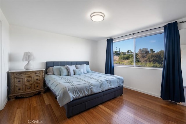 bedroom with dark hardwood / wood-style flooring