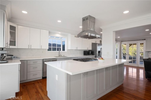 kitchen featuring french doors, appliances with stainless steel finishes, dark hardwood / wood-style flooring, white cabinetry, and island exhaust hood