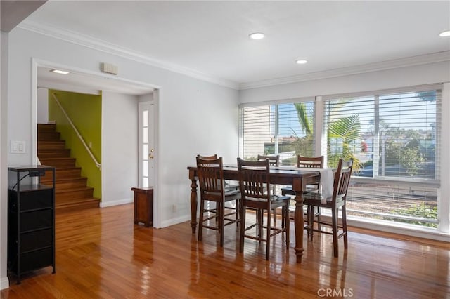 dining area featuring hardwood / wood-style floors, a healthy amount of sunlight, and ornamental molding