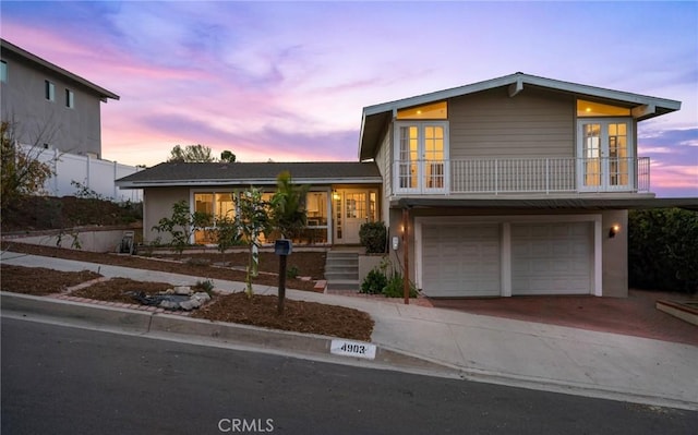 view of front of property featuring a balcony and a garage