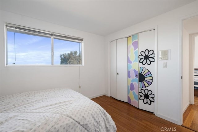 bedroom with a closet and hardwood / wood-style flooring