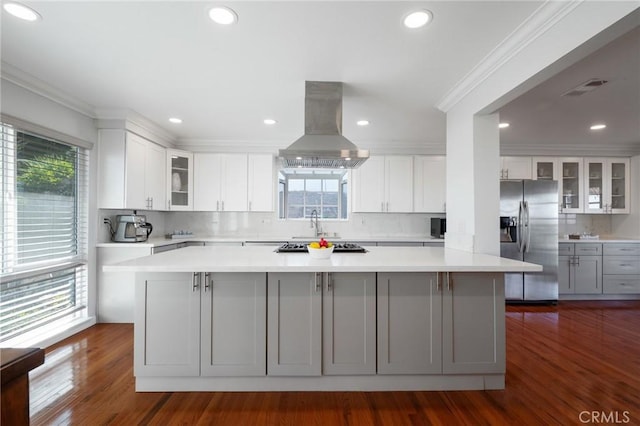 kitchen with white cabinets, stainless steel fridge with ice dispenser, island range hood, and a large island