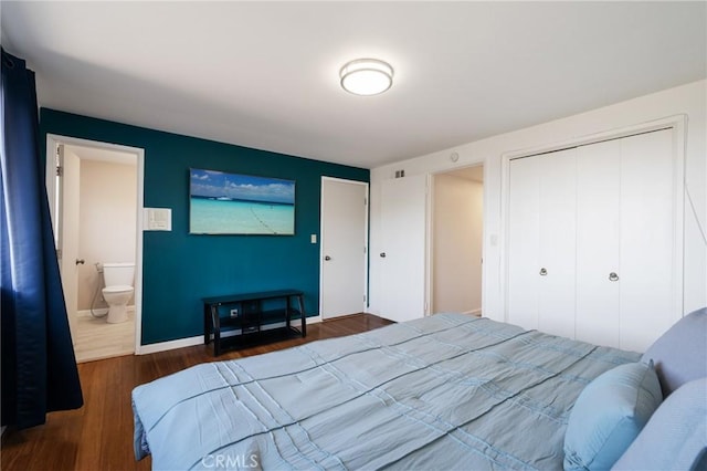 bedroom with dark hardwood / wood-style flooring, connected bathroom, and a closet