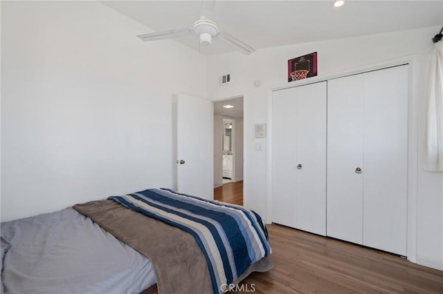 bedroom featuring ceiling fan, vaulted ceiling, wood-type flooring, and a closet