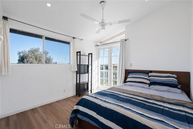 bedroom featuring ceiling fan, vaulted ceiling, light hardwood / wood-style flooring, and multiple windows