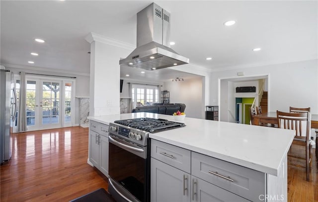 kitchen with hardwood / wood-style floors, french doors, crown molding, range hood, and stainless steel appliances