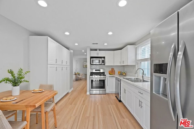 kitchen with sink, white cabinets, and appliances with stainless steel finishes